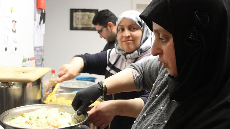 Wafaa Mahmoud, Amira Hamou und Ali Al Jirudi sorgen dafür, dass der immer anders gewürzte Reis nicht kleben bleibt. Foto: Sonny Adam