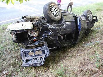Der 17 Jahre alte BMW blieb nach der Schleuderfahrt auf dem Dach liegen. Foto: Eckehard Kiesewetter