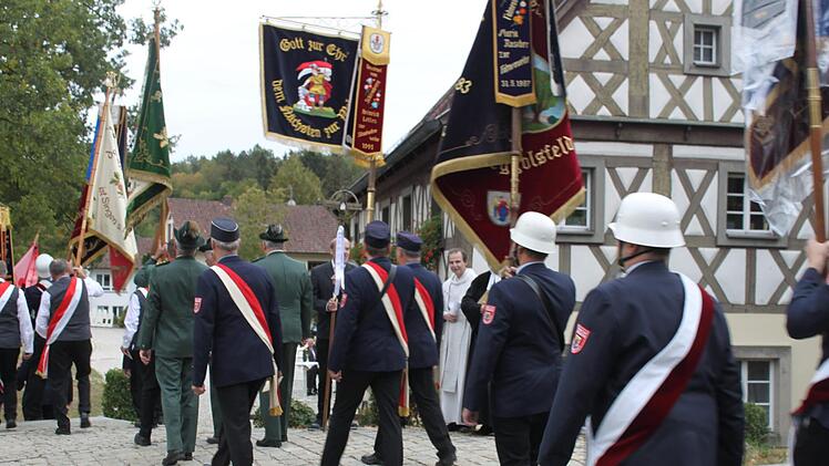 Vertreter der Vereine mit ihren Fahnen begleiteten die geladenen Gäste von der Kirche zur Oertelscheune.Foto: Carmen Schwind