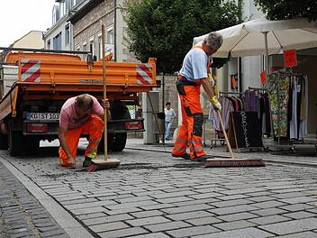 Bauhofmitarbeiter kehren Splitt zwischen das Pflaster.Foto: Arkadius Guzy