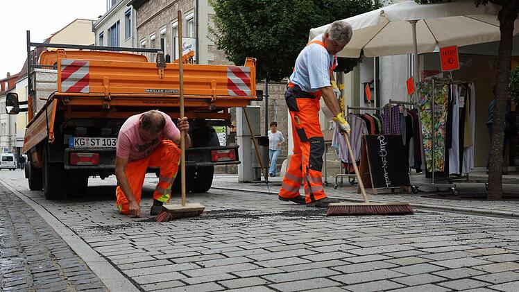 Bauhofmitarbeiter kehren Splitt zwischen das Pflaster.Foto: Arkadius Guzy