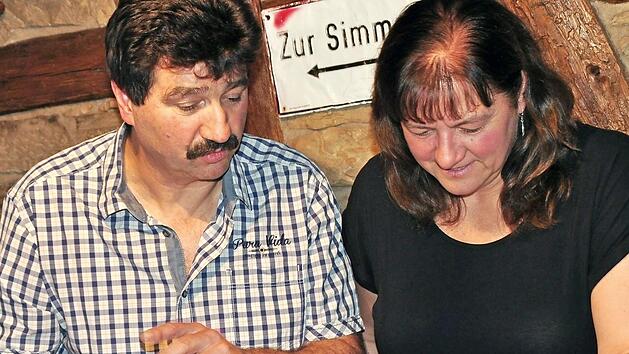 Uwe und Andrea Rädlein schwelgen in Erinnerungen. Sie schauen sich die Bilder in ihren Foto-Alben mit den vielen Veranstaltungen im Tunnelsaal oder beim traditionellen Taubenmarkt an. Ob es jemals wieder so kommen wird? Fotos: Simon Albrecht