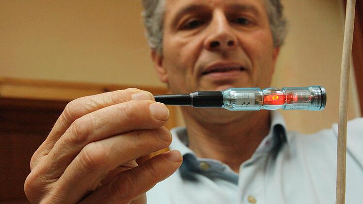 Er sieht Rot: Dr. Dietrich Moldan misst das elektrische Wechselfeld unmittelbar neben einem Nachttischlampen-Kabel.  Fotos: Diana Fuchs