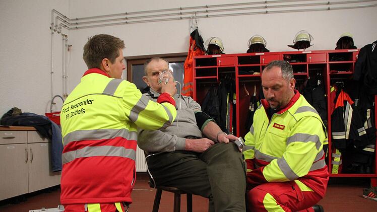 Matthias Hauke (links) und Torsten Hereth demonstrieren einen Einsatz der First Responder Gruppe der Zeitlofser Feuerwehr. Der 81-jährige Michael Schneider machte gerne bei der Übung mit, denn er hat schon mehrfach von der schnellen Hilfe profitiert. Foto: Ulrike Müller