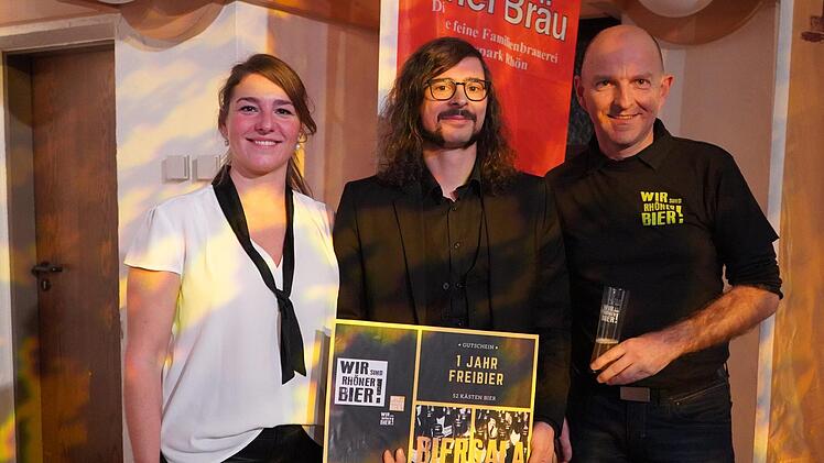 Philipp Ißbrücker (Mitte) hat den diesjährigen Videowettbewerb und somit ein Jahr Freibier in Form von 52 Kästen Rhöner Bier gewonnen. Zu den ersten Gratulanten zählten Manuela Michel, Projektverantwortliche der Rhön GmbH für die Initiative "Wir sind Rhöner Bier", und Thorn Plöger, Geschäftsführer der Rhön GmbH. Foto: Kathrin Kupka-Hahn