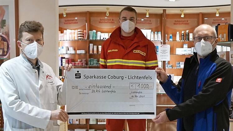 Hartmut Pensel, Inhaber Rats-Apotheke Lichtenfels (von links), Bastian Bernhardt, Technischer Leiter der DLRG Lichtenfels, und Hans Fritzmann, Vorsitzender der DLRG Lichtenfels, bei der Übergabe des symbolischen Spendenschecks