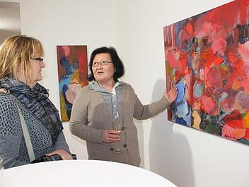 Lucia Scheid-Nam (rechts) zeigt Gundi Bezold ihr farbenfrohes Bild "Nach dem Sommer".Stephan Stöckel