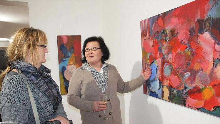 Lucia Scheid-Nam (rechts) zeigt Gundi Bezold ihr farbenfrohes Bild "Nach dem Sommer".Stephan Stöckel