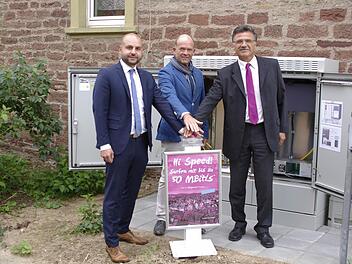Der gesicherte Kabel- und Schaltschrank am Deisselbach steht für den Telekom-Breitbandanschluss in Elfershausen, den Vertriebsleiter Michael Gstädtner, Bürgermeister Karlheinz Kickuth und Projektleiter Klaus Markert (v. l.) offiziell in Betrieb nahmen.  Foto: Winfried Ehling