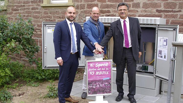 Der gesicherte Kabel- und Schaltschrank am Deisselbach steht für den Telekom-Breitbandanschluss in Elfershausen, den Vertriebsleiter Michael Gstädtner, Bürgermeister Karlheinz Kickuth und Projektleiter Klaus Markert (v. l.) offiziell in Betrieb nahmen.  Foto: Winfried Ehling