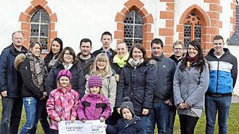 Die evangelische Landjugend Hain überreichte vor der Dreifaltigkeitskirche symbolisch eine Spende in Höhe von 500 Euro an Pfarrer Reinhold König  Foto: Karl-Heinz Hofmann