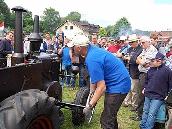 Stephan Böhmer wirft den Schlepper mit dem Lenkrad an. Viele schauen interessiert zu. Foto: Andreas Welz