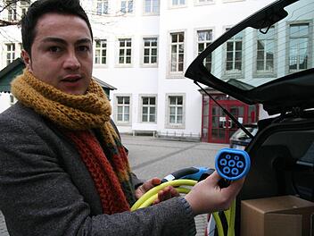 Belectric-Mitarbeiter Yusuf Akdeniz zeigt den siebenpoligen Stecker vom Typ 2, den in Zukunft alle Elektroautos haben sollen. Foto: Sabine Paulus