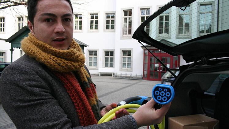Belectric-Mitarbeiter Yusuf Akdeniz zeigt den siebenpoligen Stecker vom Typ 2, den in Zukunft alle Elektroautos haben sollen. Foto: Sabine Paulus
