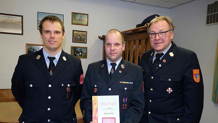 Das Ehrenkreuz des Deutschen Feuerwehr-Verbandes erhielt Tobias Fischer (Mitte) aus Diebach wegen hervorragender Leistungen. Kommandant Florian Ziegler (links) und Kreisbrandrat Benno Metz gratulierten.