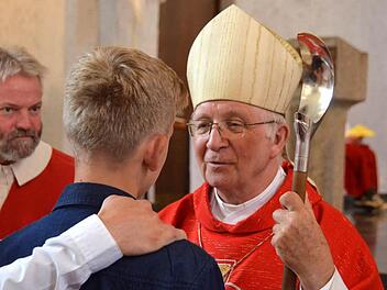 Weihbischof Ulrich Boom spendet einem jungen Mann das Sakrament der Firmung. Foto: Peter Rauch
