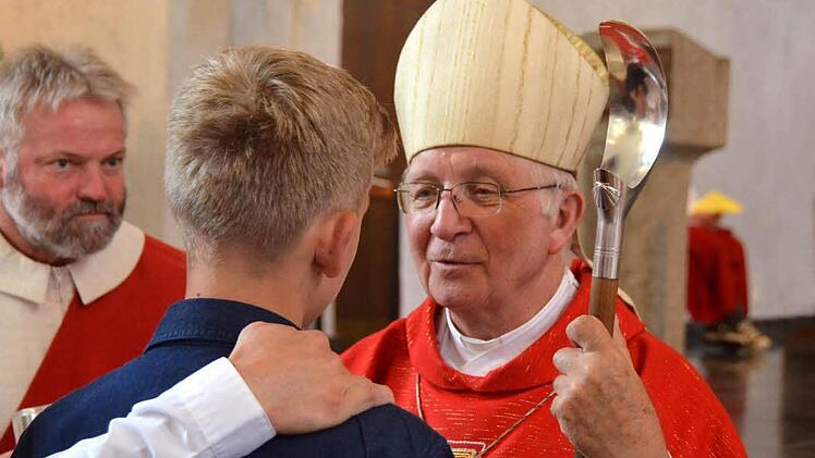 Weihbischof Ulrich Boom spendet einem jungen Mann das Sakrament der Firmung. Foto: Peter Rauch