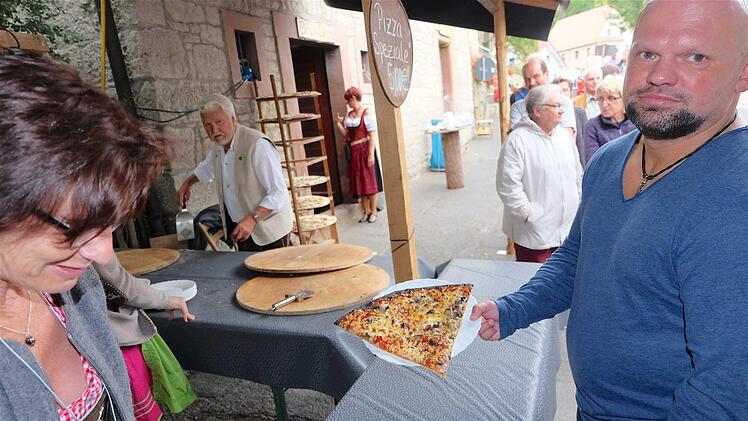 So eine Riesenpizza aus Pfaffenhausen reicht für fünf Portionen. Ein Stück gönnt sich Frank Otter (rechts). Foto: Gerd Schaar