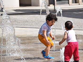 Freude pur: Rayan (3, links) und Zyan (1) mögen bei diesem Wetter das Wasserspiel am Albertsplatz am liebsten.