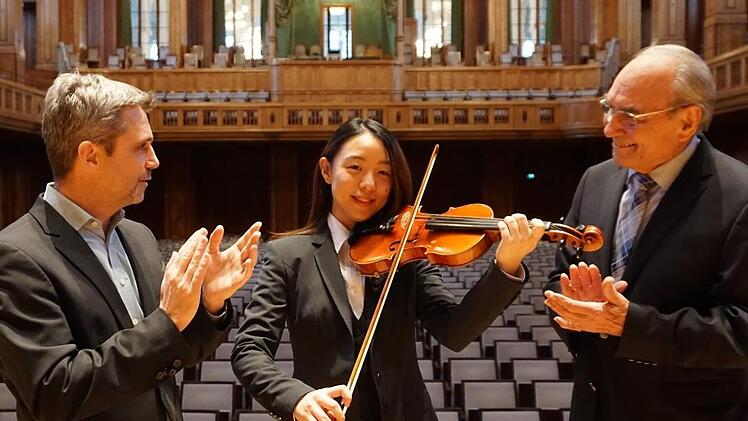 Frank Oette, Kurdirektor und Gesch&auml;ftsf&uuml;hrer der Bayer. Staatsbad Bad Kissingen GmbH, und Kurt Rieder, Vorsitzender des F&ouml;rdervereins Bad Kissinger Kurorchesters e.V., hei&szlig;en Hsin-Yun Chiang im Kurorchester herzlich willkommen. Foto: Daniel Scheublein
