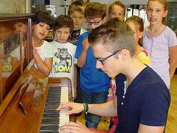 Am Klavier begleitet Sebastian Spiegel den Gesang der Kinder bei Kunstkursen. Foto: Sabine Meißner