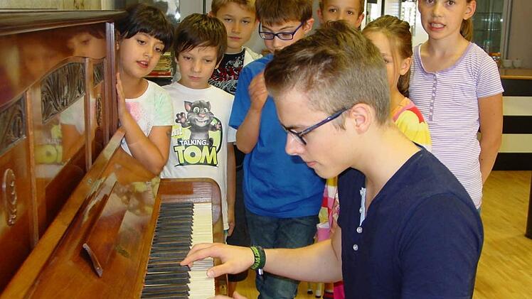 Am Klavier begleitet Sebastian Spiegel den Gesang der Kinder bei Kunstkursen. Foto: Sabine Meißner