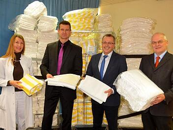 Elf große Rollcontainer voller Bettwäsche, Hand- und Badetücher, das ist die Weihnachtsspende der Kissinger Rehaklinik "Am Kurpark". Landratsamt Bad Kissingen und die Regierung von Unterfranken waren die Empfänger. Auf unserem Foto v.li: die kommissarische Chefärztin Cornelia-Alice Pape, Holger Metz, kaufmännischer Leiter der Rehaklinik, stellvertretender Landrat Emil Müller und der Sachgebietsleiter Flüchtlingsbetreuung Thomas Weingart von der Regierung von Unterfranken  Foto: Peter Rauch