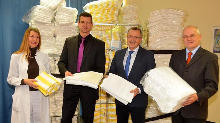 Elf große Rollcontainer voller Bettwäsche, Hand- und Badetücher, das ist die Weihnachtsspende der Kissinger Rehaklinik "Am Kurpark". Landratsamt Bad Kissingen und die Regierung von Unterfranken waren die Empfänger. Auf unserem Foto v.li: die kommissarische Chefärztin Cornelia-Alice Pape, Holger Metz, kaufmännischer Leiter der Rehaklinik, stellvertretender Landrat Emil Müller und der Sachgebietsleiter Flüchtlingsbetreuung Thomas Weingart von der Regierung von Unterfranken  Foto: Peter Rauch