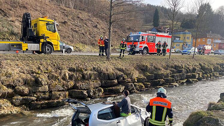 Der verunglückte Wagen in der Sinn.  Der Fahrer konnte sich nicht selbstständig aus dem Auto befreien.