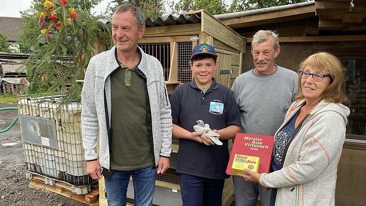 Nachwuchs-Taubenz&uuml;chter Moritz Wahn eingerahmt von seinen F&ouml;rderern Conny und Fritz Bremkes und "Pate" Bernd Mager (2.v. r.) und einem seiner Sch&uuml;tzlinge vor dem neuen Leih-Taubenschlag.