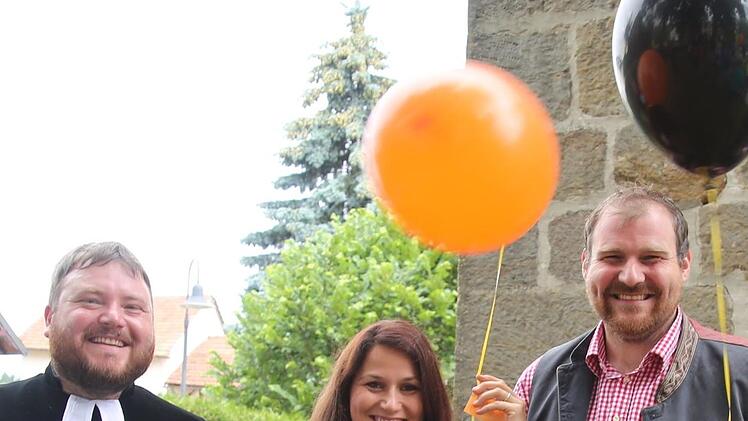 Luftballons mit der Aufschrift "750 Jahre Bischwind" hatte Pfarrer Tobias Knötig drucken lassen. Gottesdienstbesucher, wie hier Bürgermeister Martin Mittag und seine Frau Julia, ließen sie, versehen mit guten Wünschen für das Dorf, in den Himmel steigen. Foto: Bettina Knauth