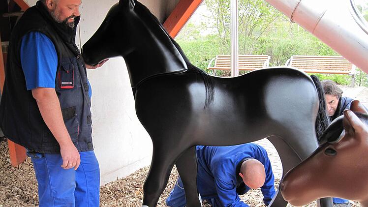 FunPark-Mitarbeiter montieren ein frisch lackiertes Pferd im Bauernhof.Foto: Playmobil