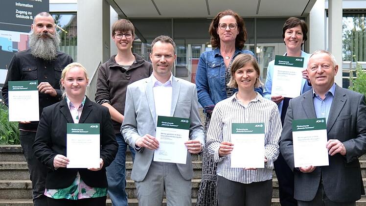 Nach der Übergabe der Förderurkunde: (von links, vorne) Projektmitarbeiterin Juliana Senft, Markus Schäfer, stellvertretender Direktor – AOK Bayern (Schweinfurt), Daniela Schmitt, Geschäftsstellenleitung der Gesundheitsregionplus Bäderland Bayeris...