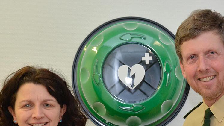 Bianca Rittelmeier und Stefan Haschke zeigen den Defibrillator, der künftig in der Polizeiinspektion Bad Kissingen hängt. Foto: Björn Hein