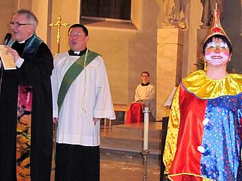 Die beiden Geistlichen  Pfarrer Gerd  Kirchner und Diakon Kim Sell sind dezent geschmückt mit Luftschlangen, Kirchenclown Sonja Spahn ist indes voll  maskiert. Foto: Thomas Dill