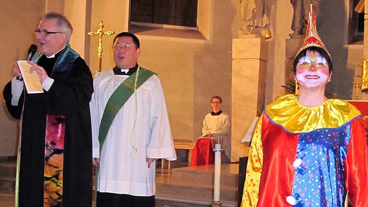 Die beiden Geistlichen  Pfarrer Gerd  Kirchner und Diakon Kim Sell sind dezent geschmückt mit Luftschlangen, Kirchenclown Sonja Spahn ist indes voll  maskiert. Foto: Thomas Dill