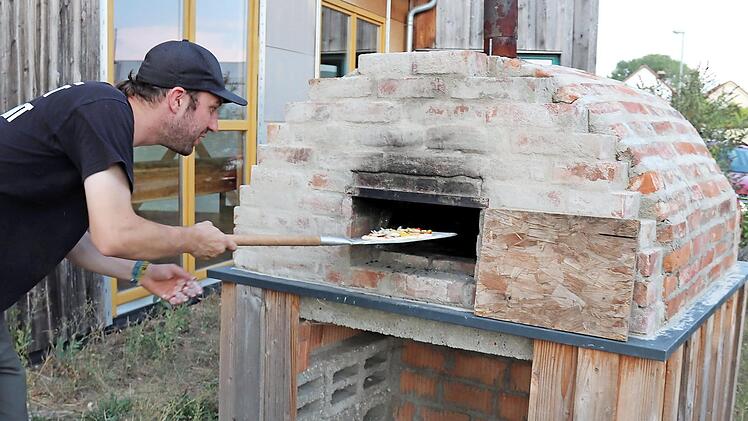 Einer der Pfadfinder beim ersten Testen des neuen Ofens Foto: J. Blum