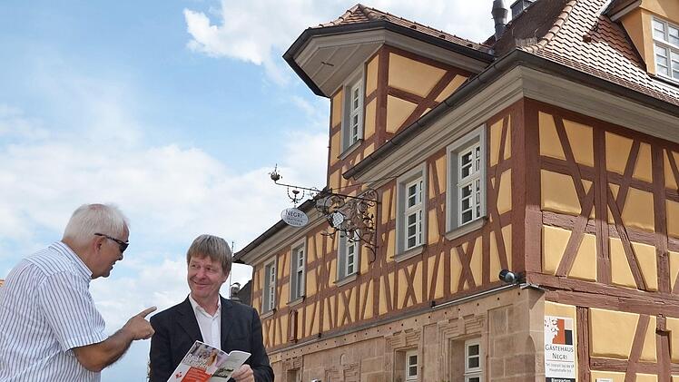 Die beiden Autoren Manfred Welker (rechts) und Gotthard Lohmaier vor dem historischen Anwesen in der Hauptstraße 71, früher Brauerei Zimmerer, später Polster. Auch heute beherbergt das Gebäude ein Lokal.  Foto: Bernhard Panzer