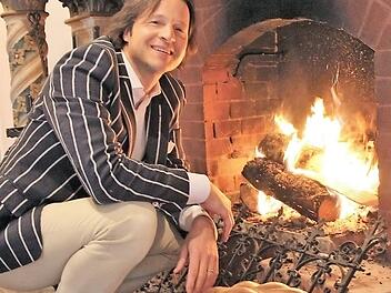 Hermann von Rotenhan schürt ein: Er mag die behagliche Atmosphäre im Kaminzimmer. Überhaupt ist Schloss Eyrichshof ihm ans Herz gewachsen. Er möchte den Familienbesitz halten. Offen und ehrlich berichtet er in seinem Buch-Debüt davon, was das bedeutet. Foto: Diana FuchsDiana Fuchs