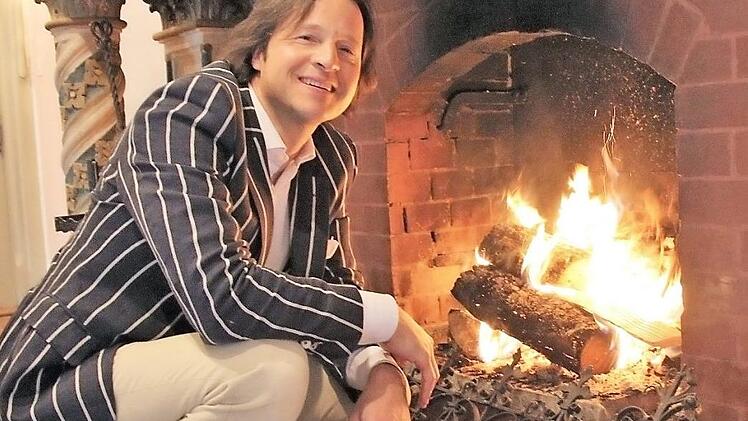 Hermann von Rotenhan schürt ein: Er mag die behagliche Atmosphäre im Kaminzimmer. Überhaupt ist Schloss Eyrichshof ihm ans Herz gewachsen. Er möchte den Familienbesitz halten. Offen und ehrlich berichtet er in seinem Buch-Debüt davon, was das bedeutet. Foto: Diana FuchsDiana Fuchs