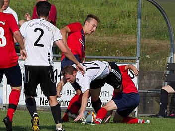 TSV Neukenroth - DJK-SV Neufang: G&auml;stespieler Manuel Gebhardt (wei&szlig;es Trikot) wird von zwei Neukenrothern angegriffen und vom Ball getrennt.  Foto: Heinrich Wei&szlig;