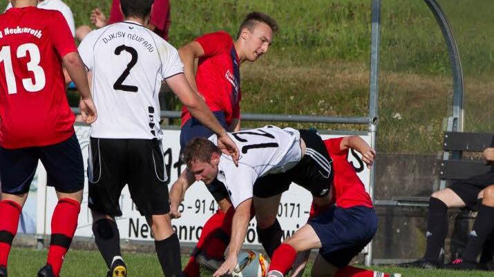 TSV Neukenroth - DJK-SV Neufang: G&auml;stespieler Manuel Gebhardt (wei&szlig;es Trikot) wird von zwei Neukenrothern angegriffen und vom Ball getrennt.  Foto: Heinrich Wei&szlig;