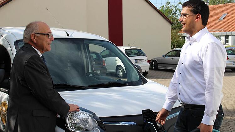 Ein Symbolbild: Erster Bürgermeister Jonas Merzbacher (rechts) mit Ladekabel und E-Fahrzeug an der Stelle, wo künftig eine Ladesäule für Elektromobile stehen wird. Das freut insbesondere Zweiten Bürgermeister Robert Martin, Klimaschutzbeauftragter des Landkreises. Foto: Kathrin Krug