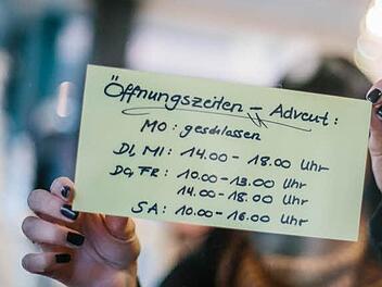 Die Mitarbeiterin eines Kronacher Geschäfts bringt eine Übersicht mit Öffnungszeiten an. Wie man sieht, werden die theoretisch realisierbaren Zeiten - etwa Wochentags bis 20 Uhr - nicht voll genutzt. Foto: Steffens