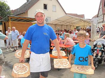 Andreas Omert wurde beim Transport des Zwiebelploatz zum Backhaus vom neunjährigen Carlos Hahl eifrig unterstützt. Foto: Eckert