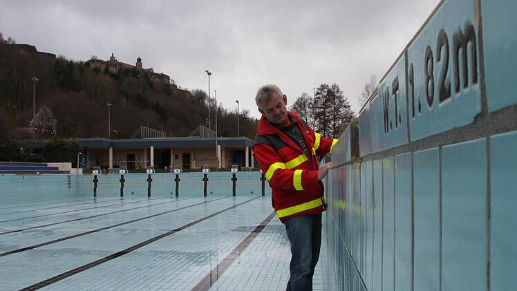 Reiner Foltes schaut sich die beschädigten Fliesen an, die im Sportbecken ausgetauscht werden müssen. Die Vorbereitungen im Kulmbacher Freibad auf die Saison laufen derzeit schon wieder auf Hochtouren. Fotos: Sebastian Martin