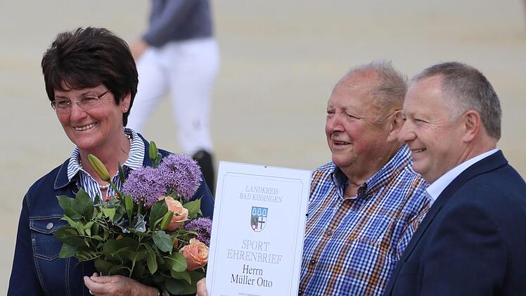 Landrat Thomas Bold (rechts) verlieh den Sport-Ehrenbrief des Landkreises an Otto Müller  vom Reiterhof Rhön (Mitte). Blumen gab es für Ehefrau Irma Müller. Foto: Sebastian Schmitt