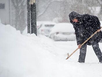 Der Neuschnee lässt sich leicht mit einem Fächerbesen zur Seite kehren. Symbolbild: Tobias Hase/dpa