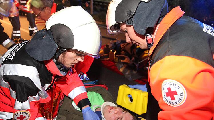 Ein Rettungsteam versorgt einen Patienten. Der Mann war zuvor zusammen mit zwei anderen Insassen in einem Auto eingeklemmt und schwer verletzt.
