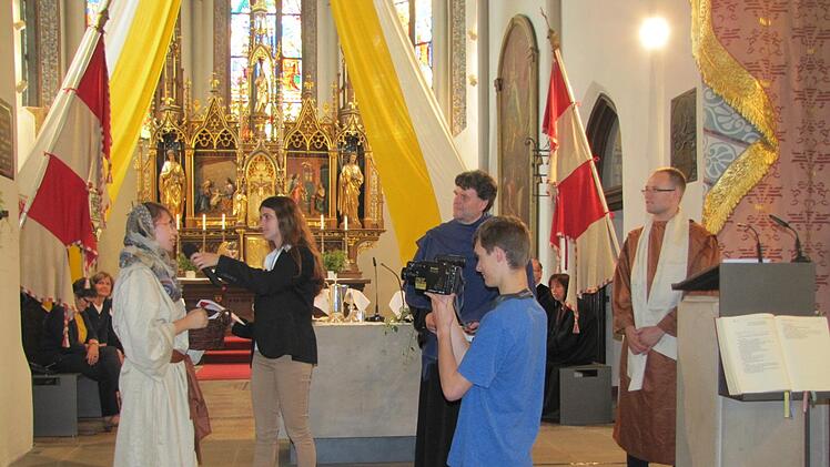 Ein Szenenspiel der Evangelischen Jugend zum Predigttext aus dem Buch des Propheten Jeremia war ein Höhepunkt im Verkündigungsteil des Festgottesdienstes am Dekanatskirchentag in Seßlach. Unser Bild zeigt von links Licia Herold als Israelin in der baylonischen Gefangenschaft, Laura Bautz als Reporterin des imaginären Fernsehsenders TV Temple News, Pfarrer Helmuth Bautz als energischen Propheten, Paul Vincent als Kameramann von TV Temple News und Simon Croner als moderaten  Propheten. Foto: Ma...